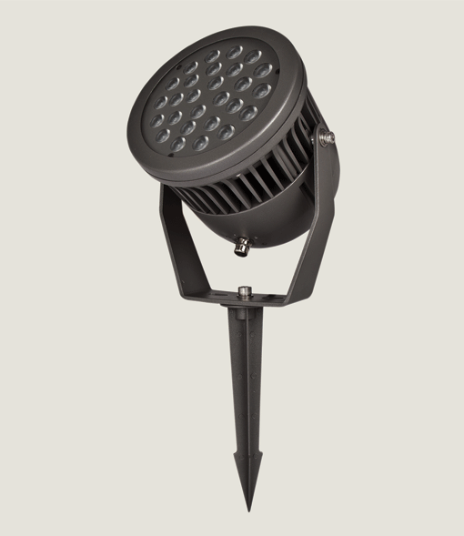 A black outdoor spotlight with an spike accessory on a grey background.