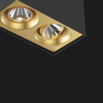 A black and gold suspended box pendant light on a black background.