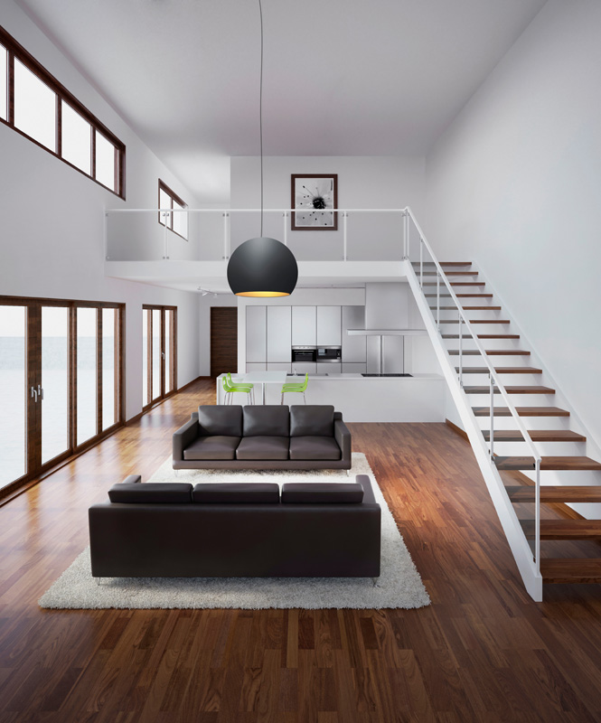 A modern living room with 2 sofas, a staircase and a black pendant light.